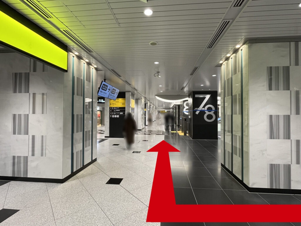 JR大阪駅西口からうめきた地下口へのアクセス：アングルが変わり、左手に先ほどの「西出口」看板、向かって右折したあとの矢印　正面に7、8番乗り場の案内柱がある