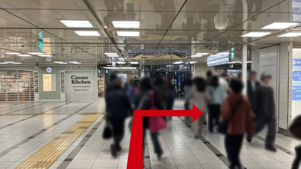 Alt：Signatureグラングリーンゲートタワーへのアクセス方法：1Fから地下1Fへと緩やかに下る通路で、左側にシャッターが下りた「Cosme Kitchen」の店舗正面が見える様子。