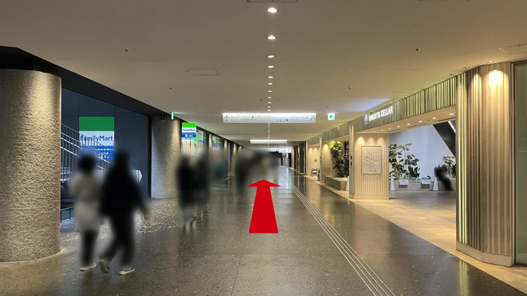 Signature グラングリーン ゲートタワーへのアクセス方法：左側に「FamilyMart」、右側に「UMEKITA CELLAR」の木目調の入り口がある地下通路を直進する様子。
