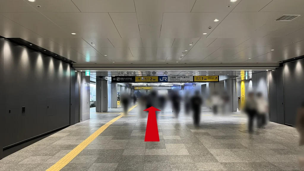Signature グラングリーン ゲートタワーへのアクセス方法：「JR大阪駅うめきた地下口」の改札付近。天井の案内板には右前方が「出口1」、左前方が「出口2」であることが示されている。