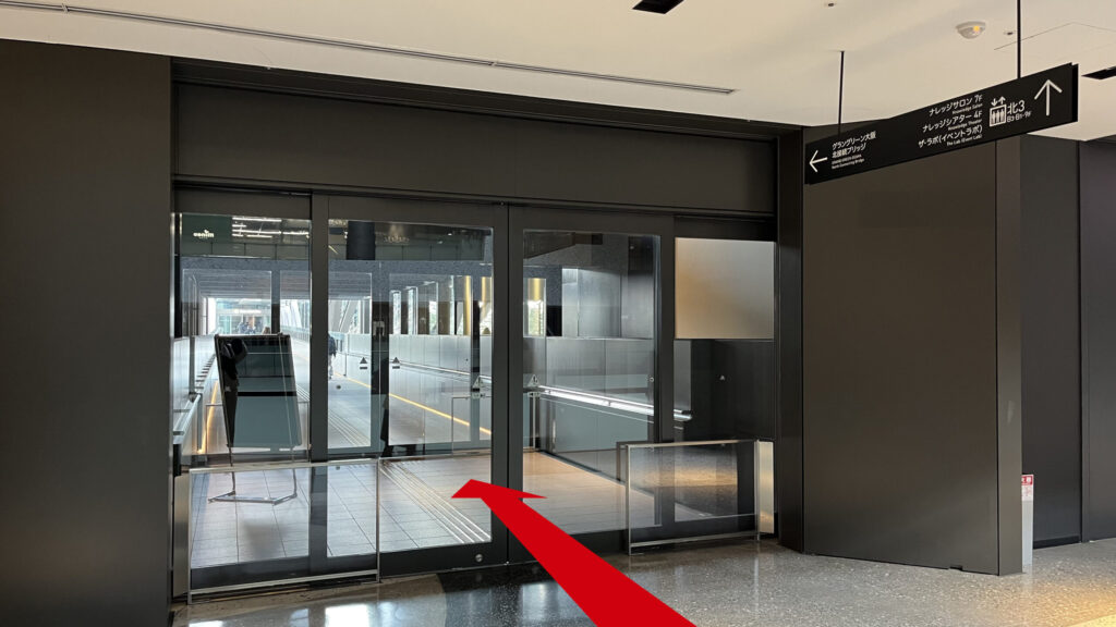 JAM BASEへのアクセス：グランフロント大阪北館の吹き抜け手前を左に曲がり進むと現れる、屋外通路へ繋がる自動ドアの写真