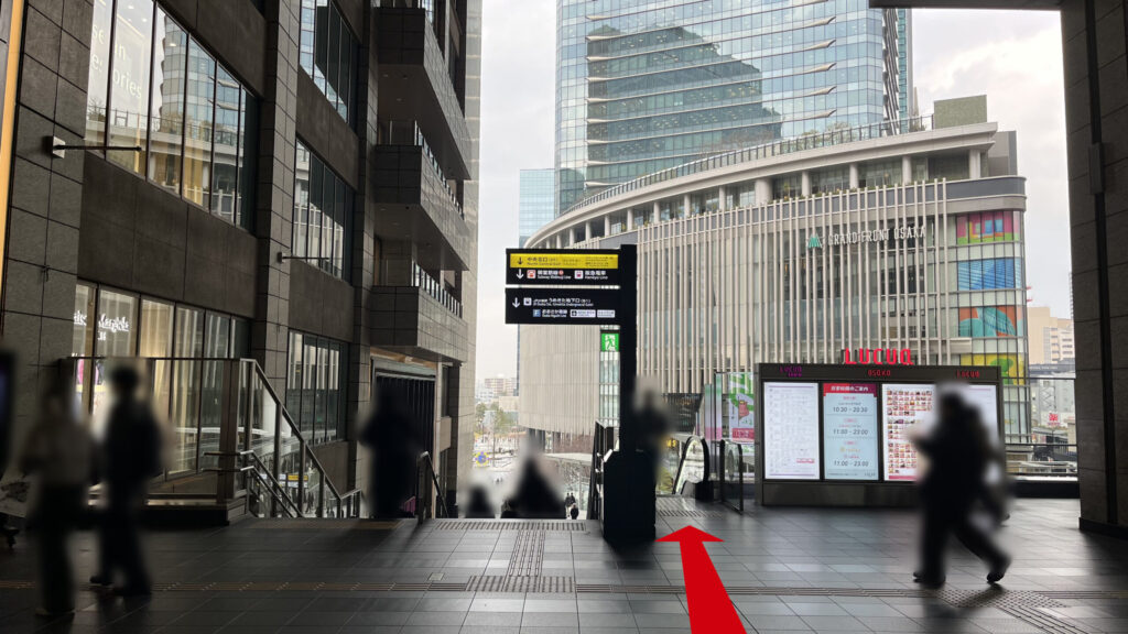 JAM BASEへのアクセス：JR大阪駅の3F改札からエスカレーター等を利用し、2Fアトリウム広場へ向かう様子