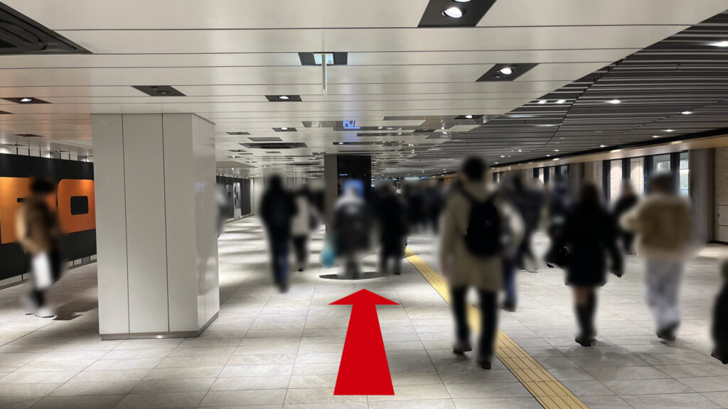 Signature大阪梅田ツインタワーズ・サウスへのアクセス：右側に阪神百貨店のショーウィンドウが続いている通路を直進する様子　左壁面には大きな広告が貼られている