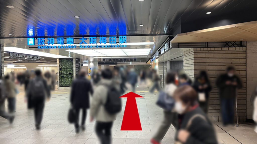 Signature大阪梅田ツインタワーズ・サウスへのアクセス：正面に「阪神電車 大阪梅田駅」の青いネオン看板を確認し、駅入り口の脇をそのまま直進する様子。