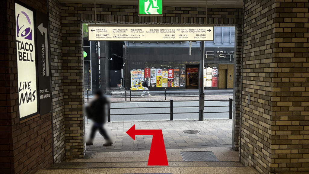 H¹O梅田茶屋町へのアクセス：タコベル横の出口を左に出て直進する様子　正面は屋外で歩道と自動車道路が見える