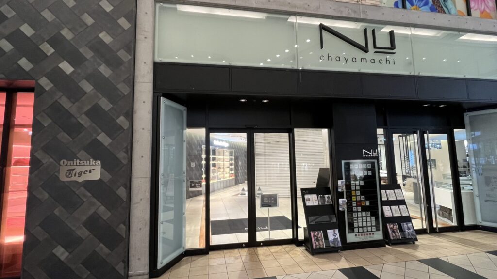 H¹O梅田茶屋町へのアクセス：NU茶屋町営業時間内の通り抜けルートについての説明画像。NU茶屋町の入口写真。左手にオニツカタイガー、右手に入口が写っている