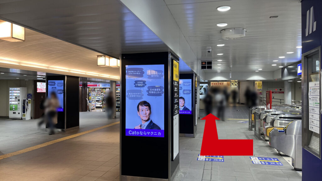 ワークスタイリング梅田へのアクセス：Osaka Metro御堂筋線梅田駅 北改札を出て右方向へ進む様子　右手に北改札、前方にデジタルサイネージが表示される柱、左奥にココカラファインがある