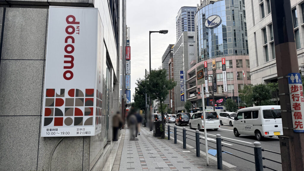 H¹O 本町へのアクセス：左側に大きな「docomo」の看板がある歩道を直進する様子