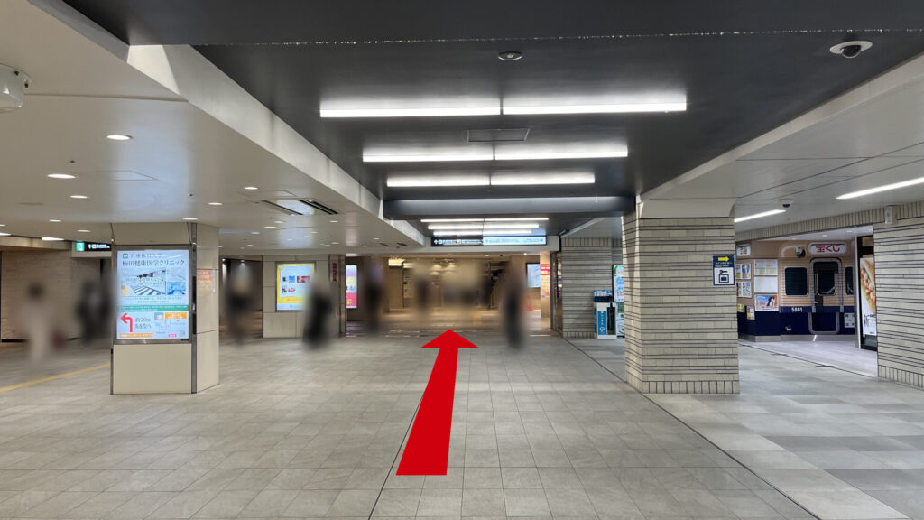 阪神大阪梅田駅の百貨店口改札を出て右に曲がった時に見える風景 右奥に宝くじ売り場、正面にディアモールへ通じている通路、通路両脇に等間隔に四角の柱が並んでいる