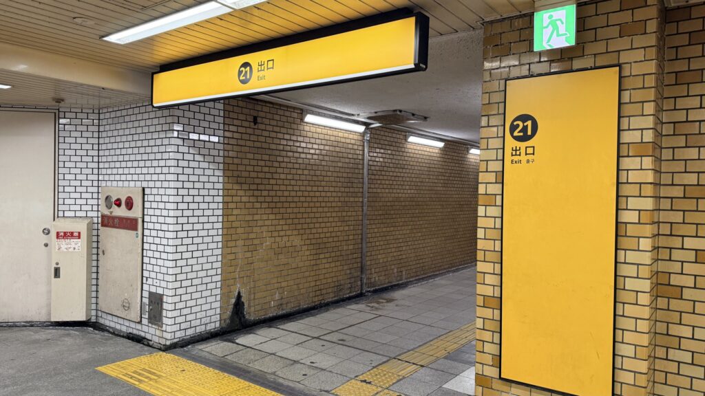 黄色い「21番出口」の看板がある階段入口