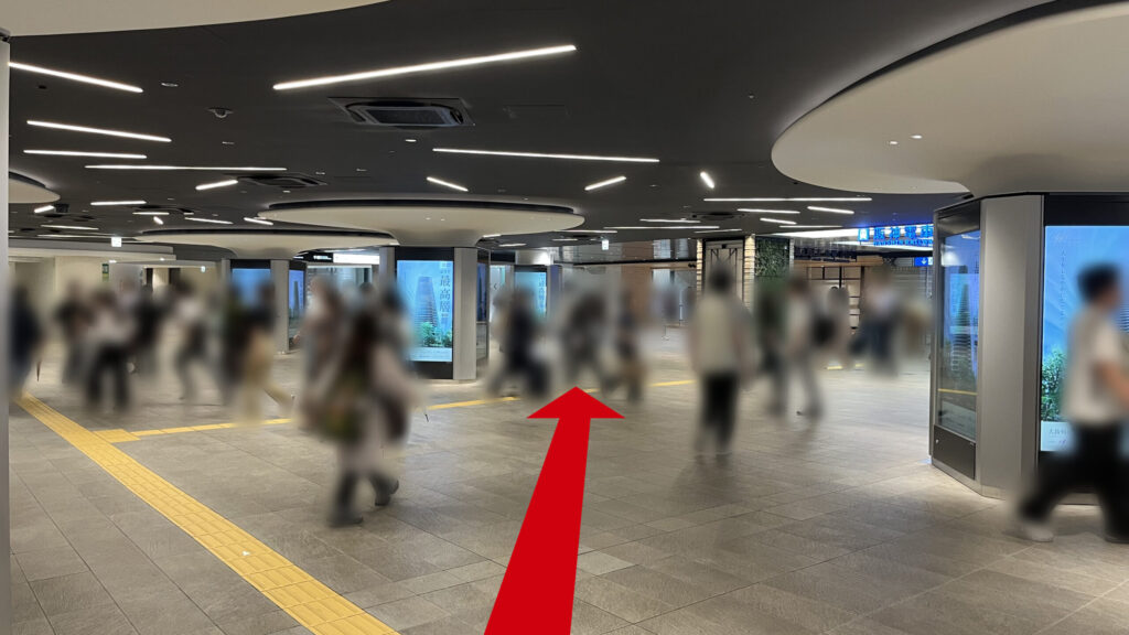 御堂筋線梅田駅や阪神大阪梅田駅が交差する地下交差点の様子 右に阪神大阪梅田駅の出口、正面に阪神百貨店があり、デジタルサイネージの四角柱が並んでいる