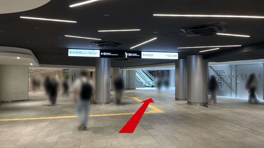 阪神百貨店の地上へ伸びるエスカレーターが正面に見える地下通路のず 左にディアモール方面へ向かう直進通路が見える