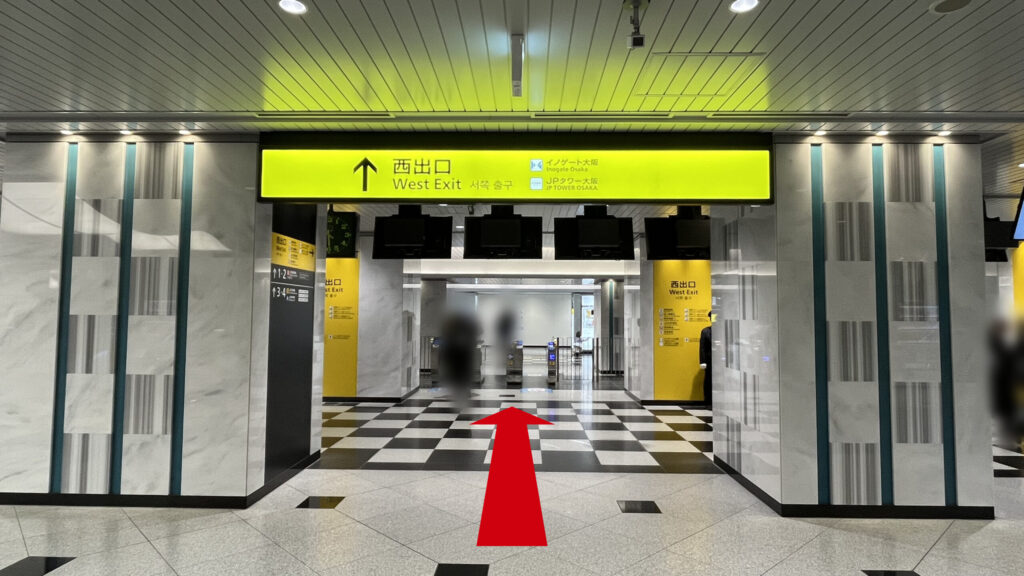 Compass Offices イノゲート大阪へのアクセス：「西出口」と書かれた黄色い看板を正面にした様子　看板には「イノゲート大阪」「JPタワー大阪」と書かれている　看板の奥には改札が見える