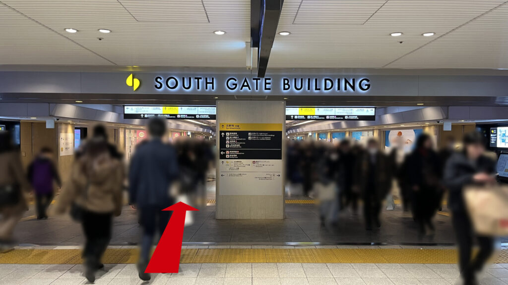 リージャス梅田スクエアビジネスセンターへのアクセス方法：頭上には「SOUTH GATE BUILDING」と書かれた大きな看板があり、その下左右にある地下の通路を直進する様子