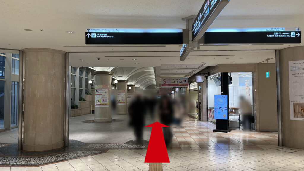 billage OSAKA 大阪駅前第1ビルへのアクセス方法:高い天井にJR北新地駅方面の案内板が吊り下げられた、ディアモール大阪の地下通路を直進する様子