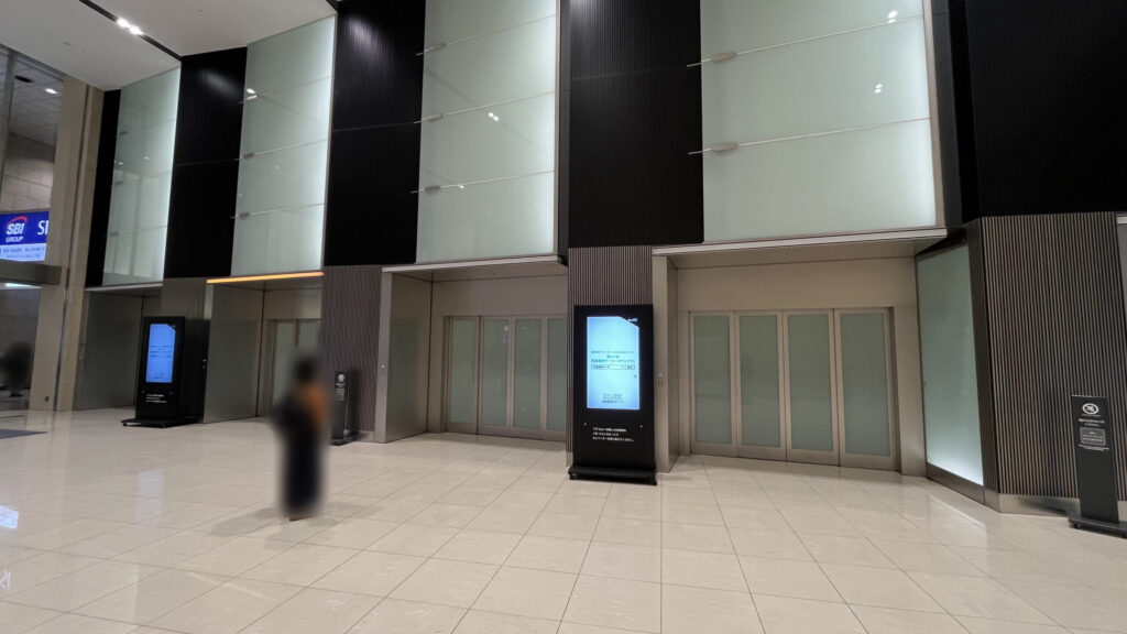 リージャス大阪梅田ツインタワーズ・ノースビジネスセンターへのアクセス：館内のオフィスロビーへ続くシャトルエスカレーター付近　大きなエレベーターが4機並んでいる