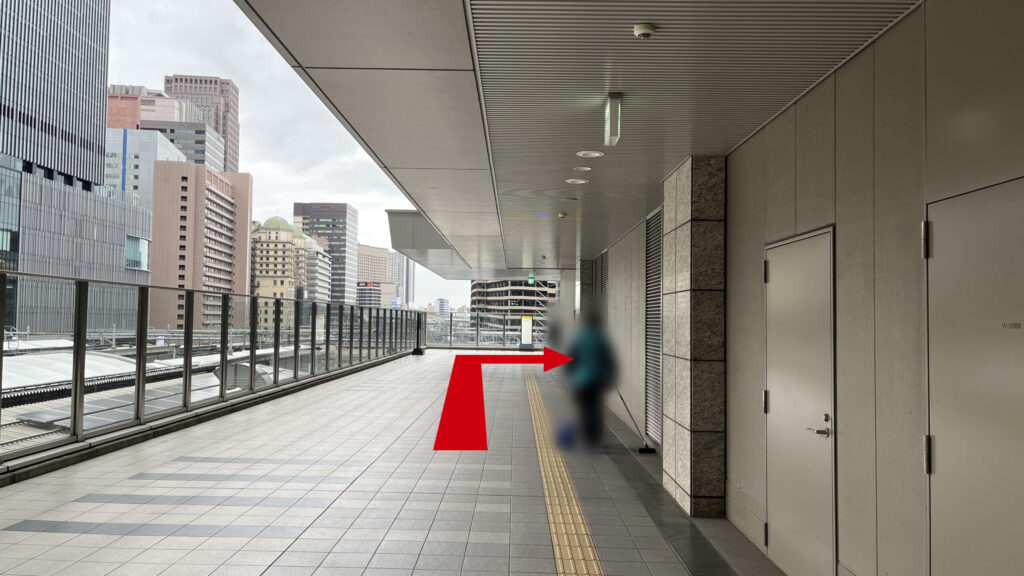 Compass Offices イノゲート大阪へのアクセス：右側に半分屋根のある通路を直進　左手にはガラス張りの柵とビル群が見える