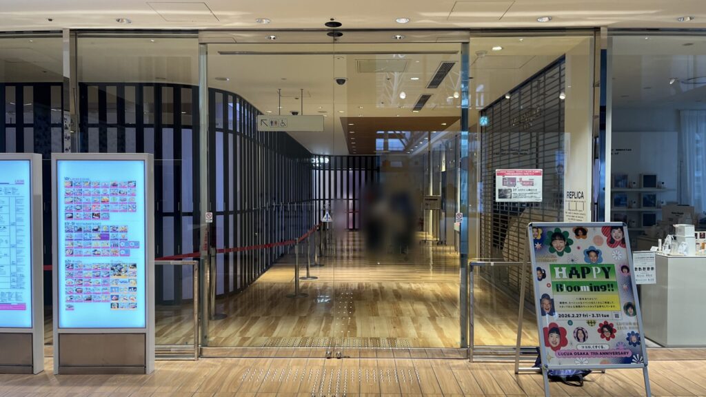 SHARE LOUNGE梅田 蔦屋書店へのアクセス：「ルクアイーレ」3F入口。ガラス扉の左側にフロアガイドが設置されており、その奥にガラスの自動扉がある　そのさらに奥右手にエレベーターホールがある