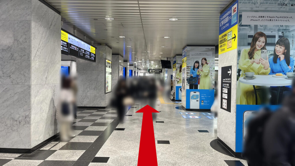 改札を出て右に曲がった図 四角い柱が等間隔に並んでおり、白黒の市松模様の床がある