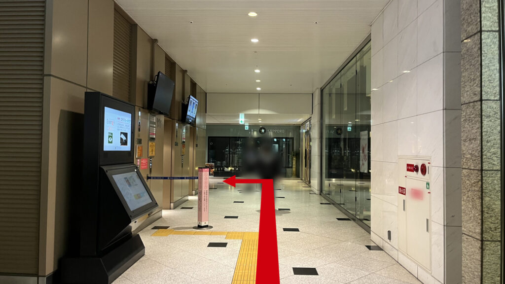 Compass Offices イノゲート大阪へのアクセス方法：案内表示があるデジタルサイネージ横の通路。左側にエレベーターが3基並んでいる