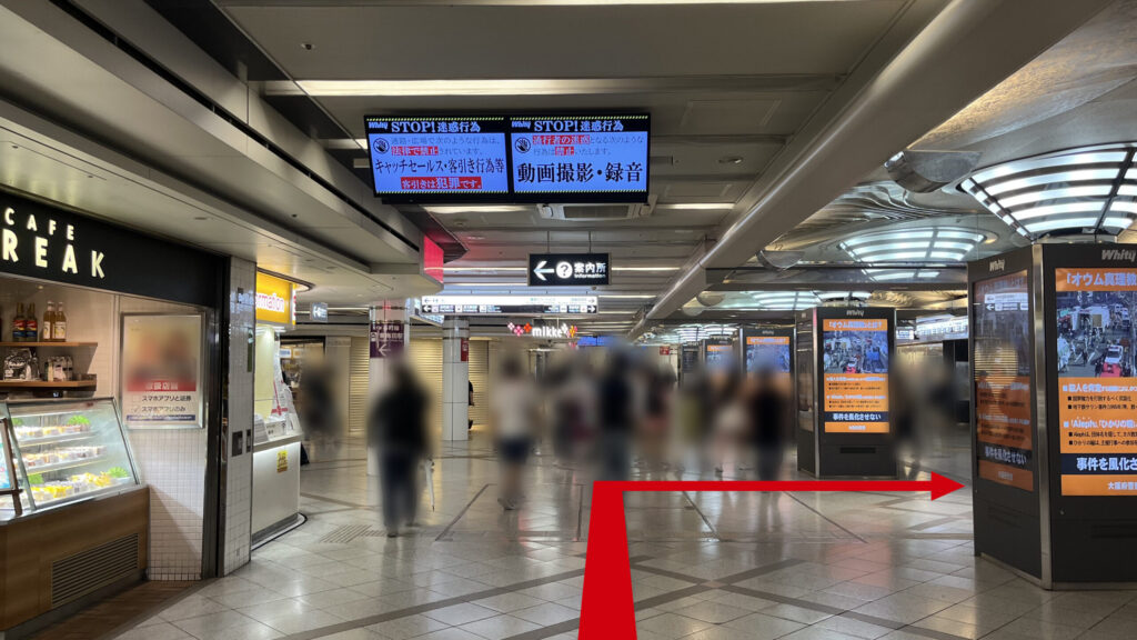 左にCAFE BREAKと宝くじ売り場、右にデジタルサイネージの四角い柱が等間隔に並ぶホワイティうめだの地下通路