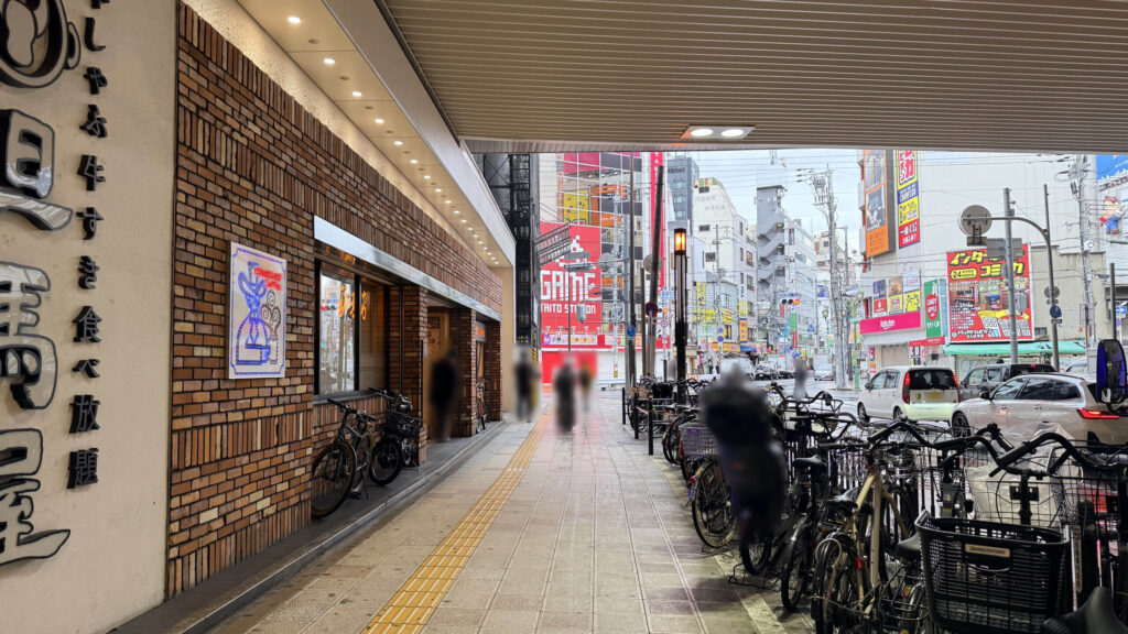 但馬屋とコメダ珈琲店が並ぶ南海の高架下通路　右側（車道横）に自転車がたくさん停まっている