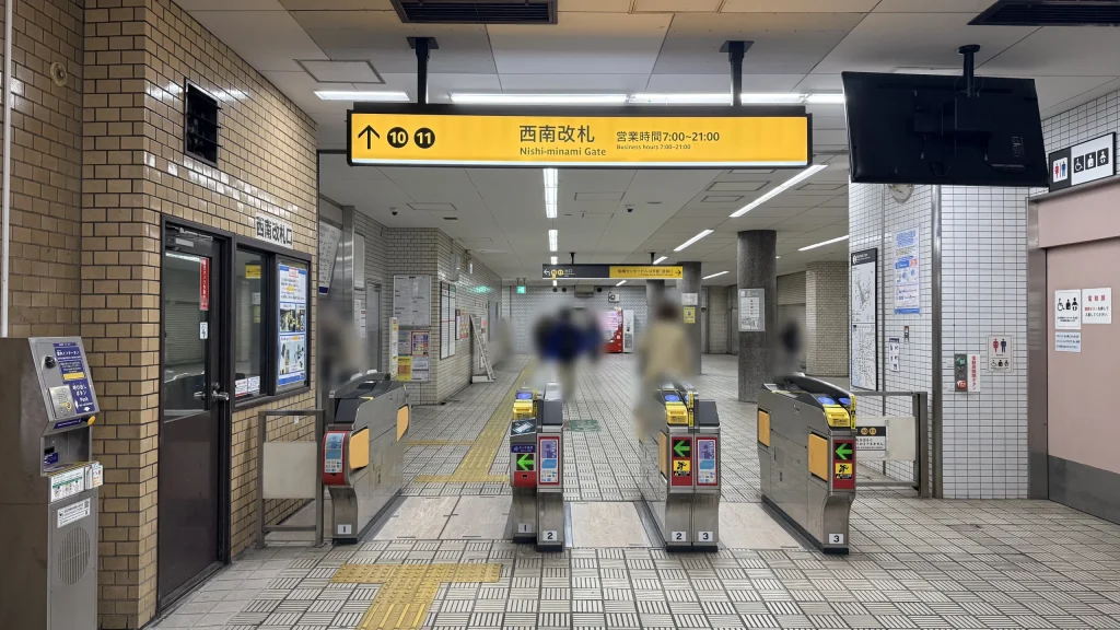 堺筋本町駅の西南改札付近にある黄色い案内看板と自動改札機の様子。