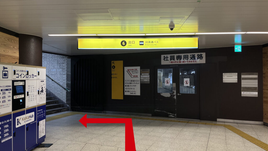 6番出口付近の写真　正面に「社員専用通路」と書かれた扉、左に6番出口への階段、その手前にコインロッカーがある