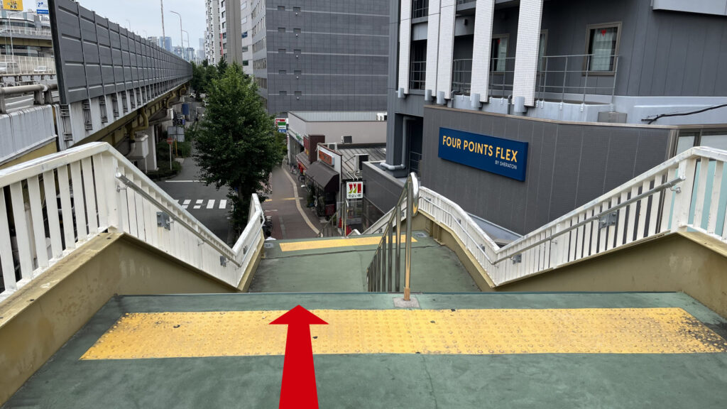 歩道橋の階段付近　白い柵に緑色に塗られた階段が下に伸びている