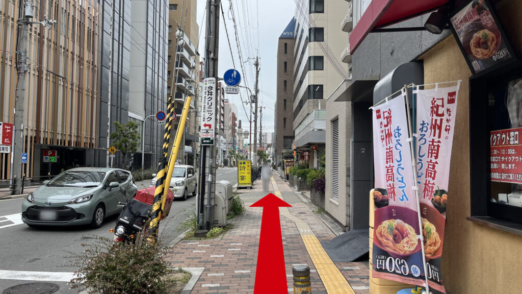 なか卯の角を右に曲がった時に見える図　右になか卯、左に道路、茶色いタイルが敷かれた歩道が続いている