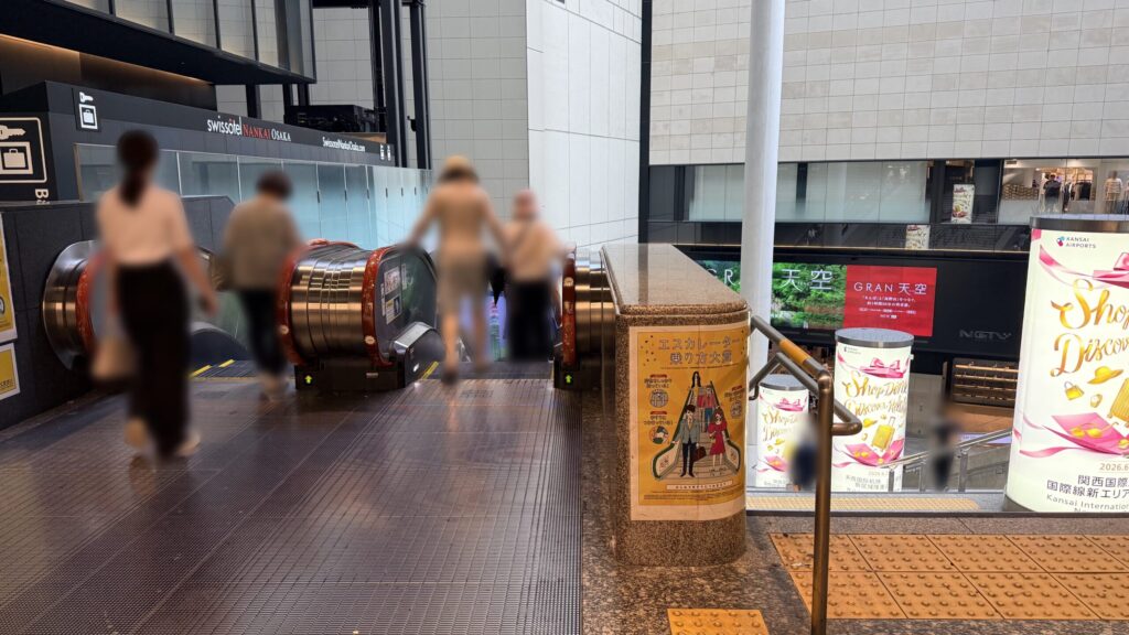 下り方向の大型エスカレーターの乗り口。前方奥には吹き抜け構造の空間が広がっている。