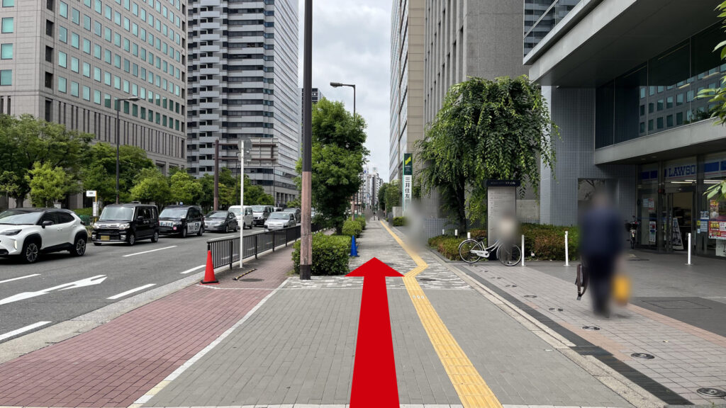 右手にローソンや三井住友銀行などの店舗やビルの敷地が並ぶ整地された歩道。黄色の点字ブロックが中央に伸びている。