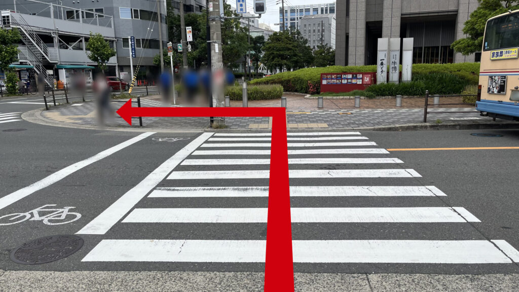 横断歩道に向かった図。目の前にはビルがあり、向こう岸の左側にもさらに横断歩道があり、見切れている。