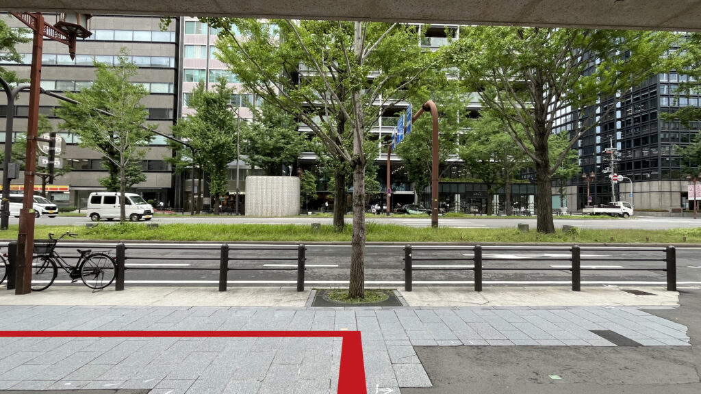 2番出口を出た時に見える風景 目の前に歩道と街路樹、その奥に御堂筋線が左右に走っている