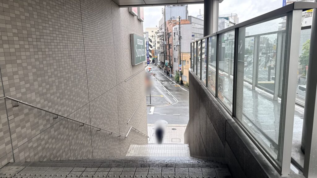 地上へ下りる屋外階段の様子。左側の壁面に「Sunplaza」の看板が掲げられている。