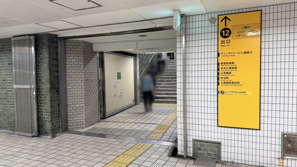地下鉄本町駅12号出口の案内看板がある地上への階段