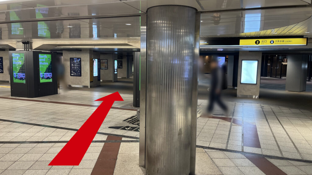 御堂筋線淀屋橋駅の北改札を出て右斜前に進む様子　前方に銀の円柱、その左右に四角柱が通路に沿って並んでいる