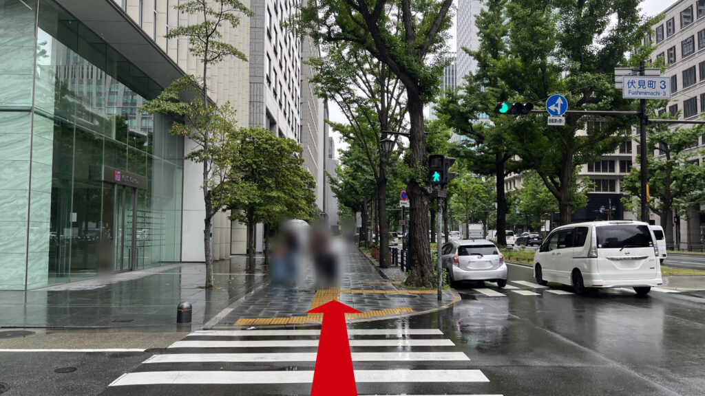 伏見町3の交差点付近の写真　左側に大きなビル、中央には歩道、右側に御堂筋が走っている