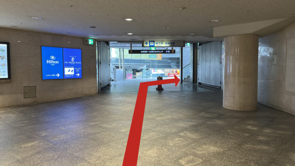 大阪第一生命ビルディングとディアモール間の連絡口 左にディアモールの飲食店の案内板とヒルトン大阪の青くて大きな案内板、正面上部に地下鉄西梅田駅と大阪第一生命ビルディングの道案内看板が出ている