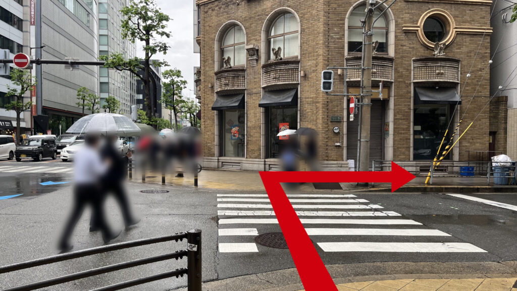 岡安証券前の交差点にある横断歩道前の写真 正面にモダンな建築がある