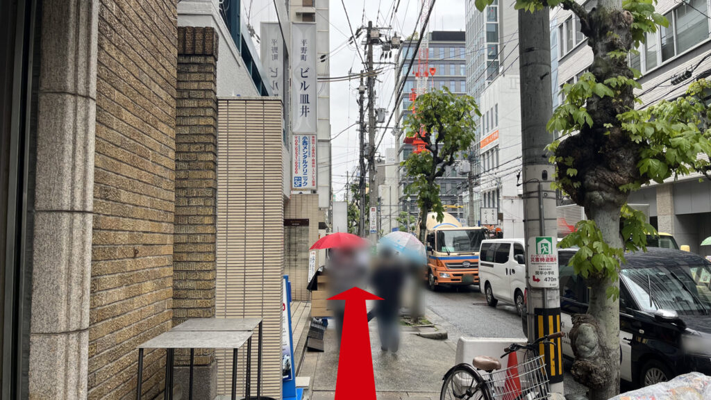 ビルや街路樹沿いの狭い歩道の写真